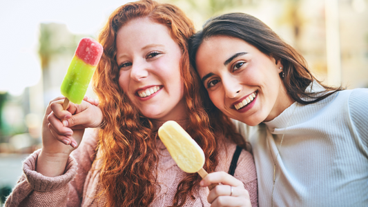 Women enjoying sugar-free frozen desserts and fruit popsicles, perfect for a keto diet during summer heat waves.