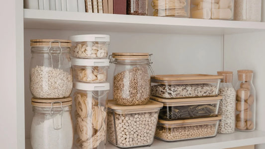 An organized kitchen pantry featuring glass jars of high-quality staples and a small container of Stevita Naturals plant-based sweetener.
